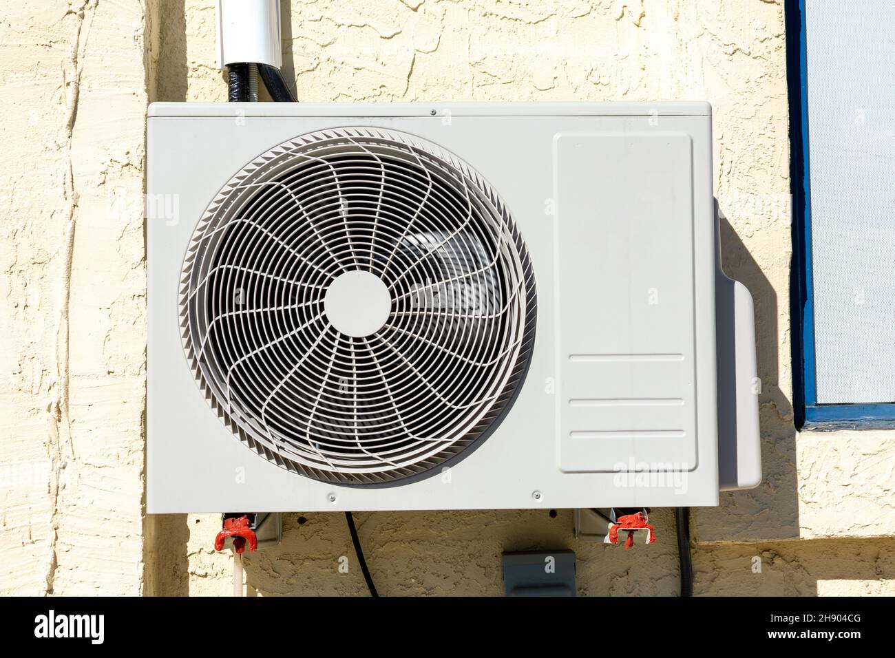 Air conditioner unit outdoor condenser installed on building wall facade. Close up Stock Photo
