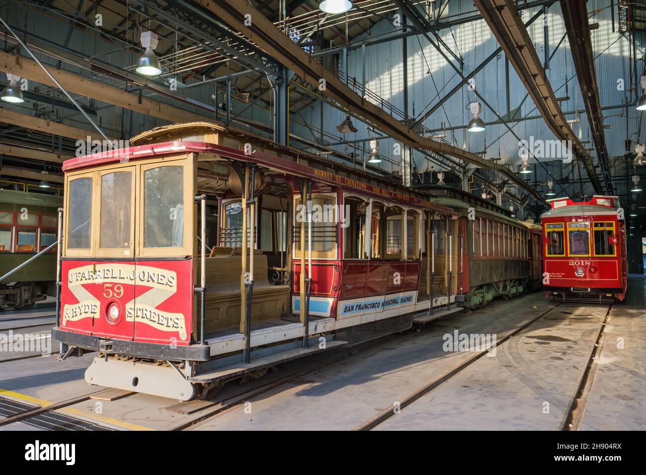 NEW ORLEANS, LA, USA - DECEMBER 2, 2021: Historic cable car from San Francisco amidst  streetcars from the St. Charles line in the Street Car Barn Stock Photo