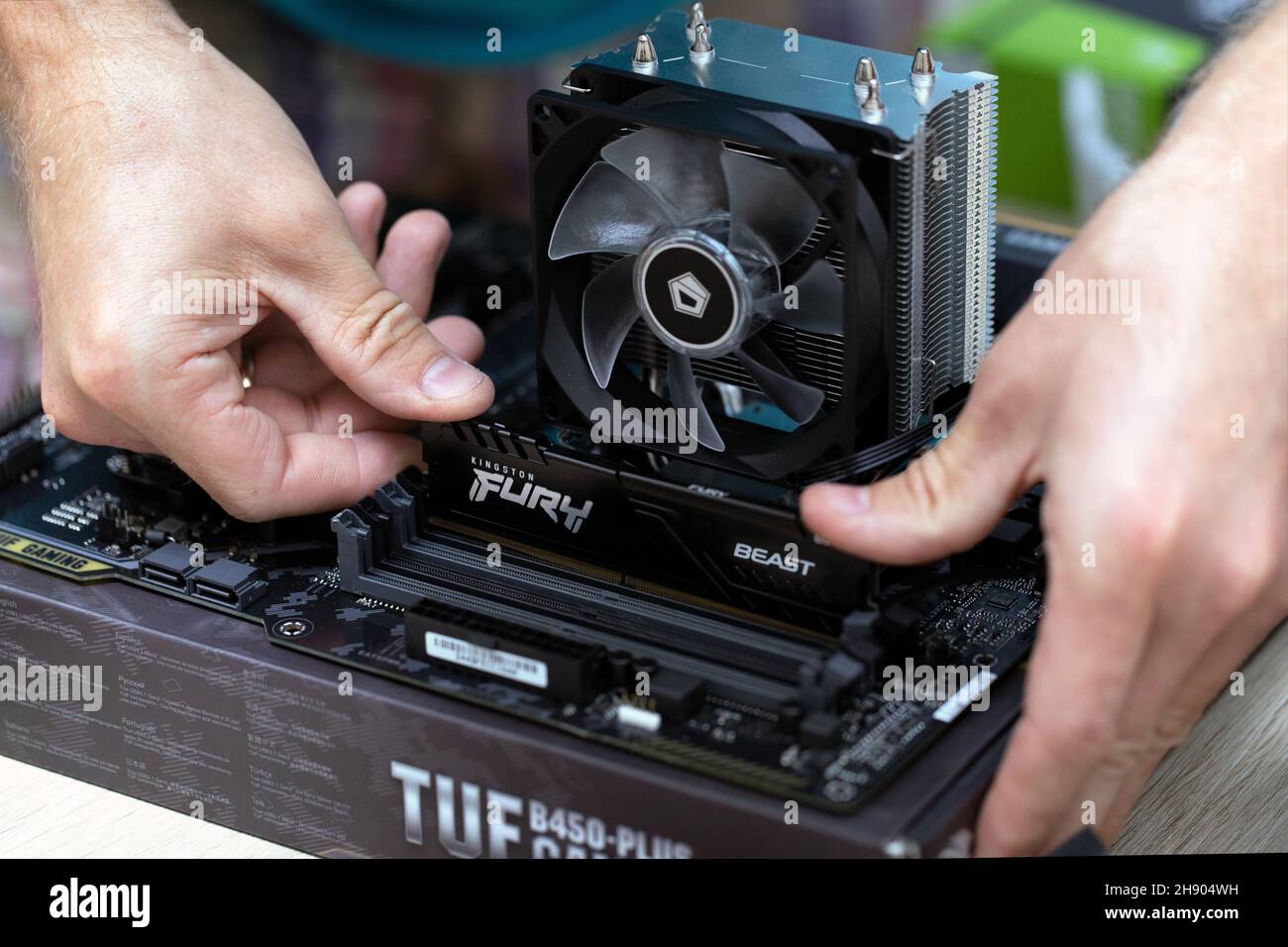 Close up of electronic engineer installing Fury Beast RAM DDR4 stick on motherboard of professional computer for cryptocurrency mining. Russia, 17.08. Stock Photo