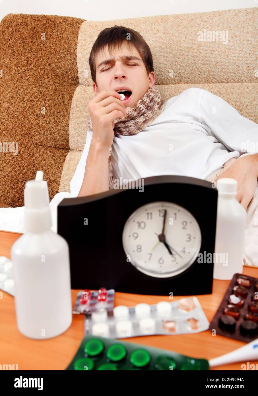 Sick Teenager take a Pill on the Bed at the Home Stock Photo