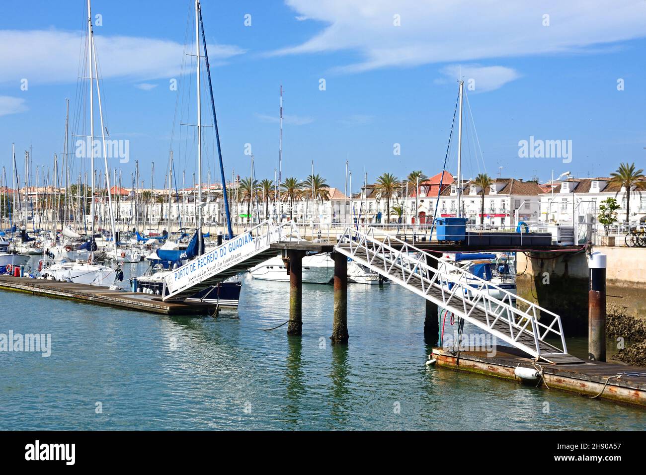 Yachts and boats moored in the marina with a footbridge in the foreground and waterfront buildings along the Avenida da Republica to the rear, Vila Re Stock Photo
