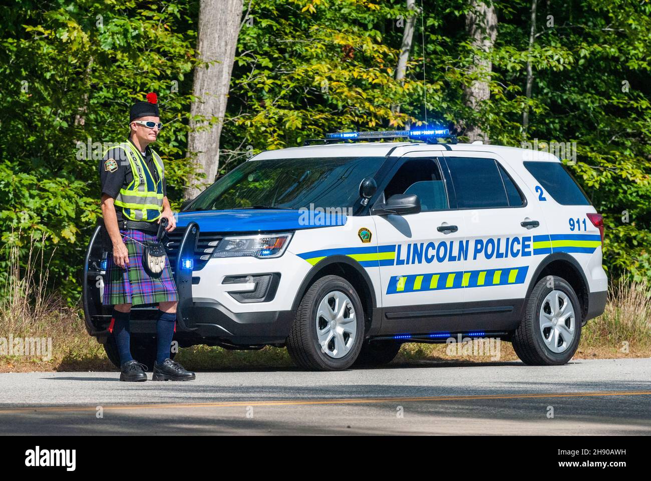 Lincoln, New Hampshire, United States of America – September 17, 2016. Police officer wearing a Scottish kilt, by a patrol car in Lincoln, NH. Stock Photo