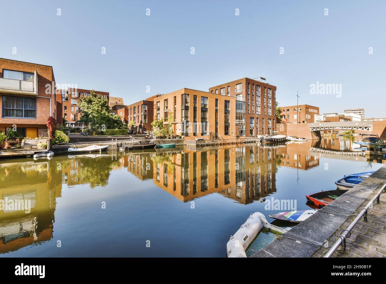 Brick buildings next to a lake with parked boats Stock Photo