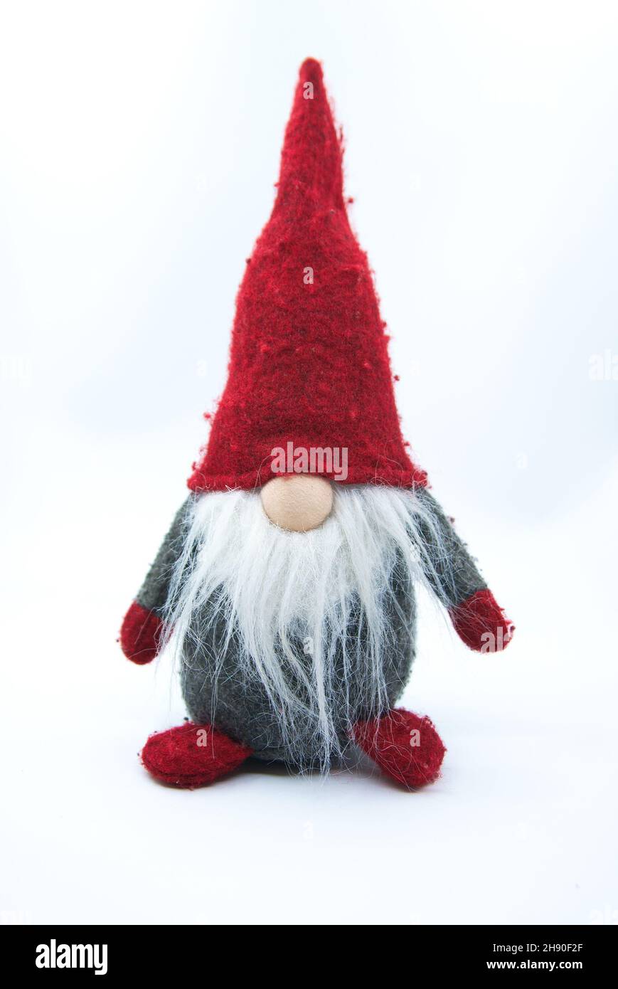 Old Christmas Gnome With White Beard in Gray Clothes and Red Hat Isolated. Winter Holidays Coming Concept. Stock Photo