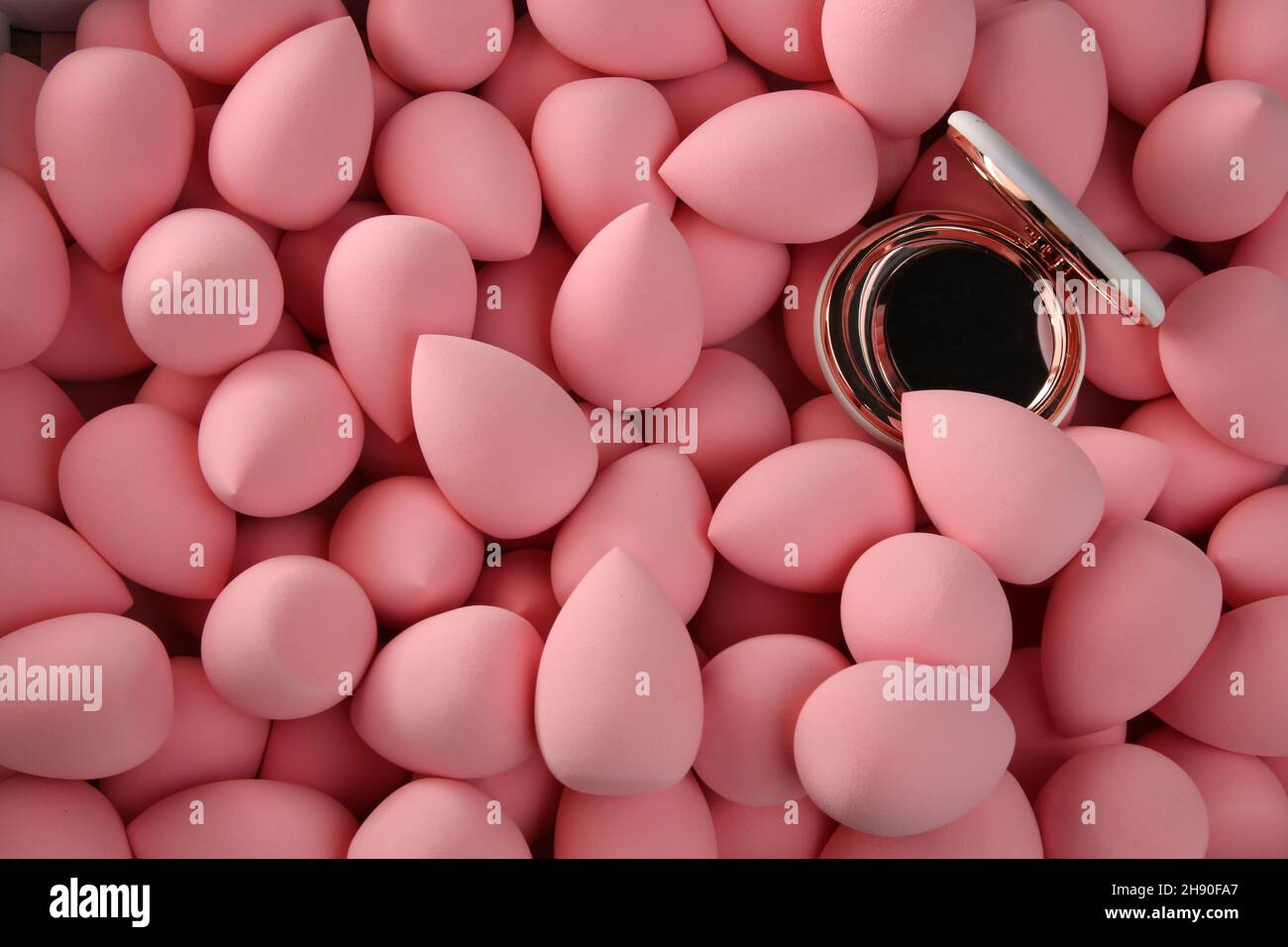 beauty background a bunch of pink gentle makeup sponges and a mirror  Stock Photo