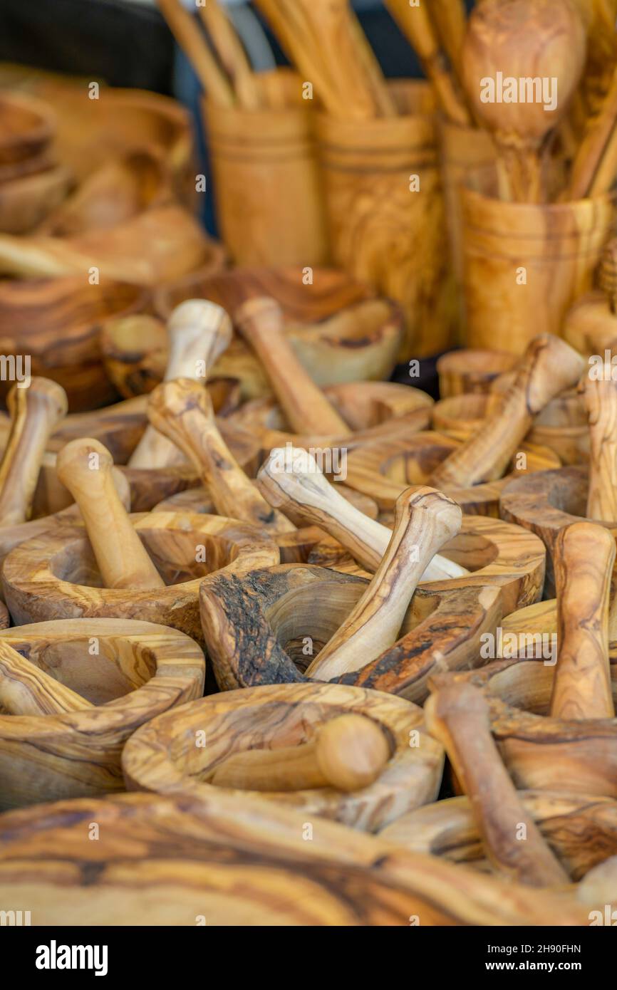 olive wood cutlery and utensils on sale at a market stall, carved olive wood from greece being