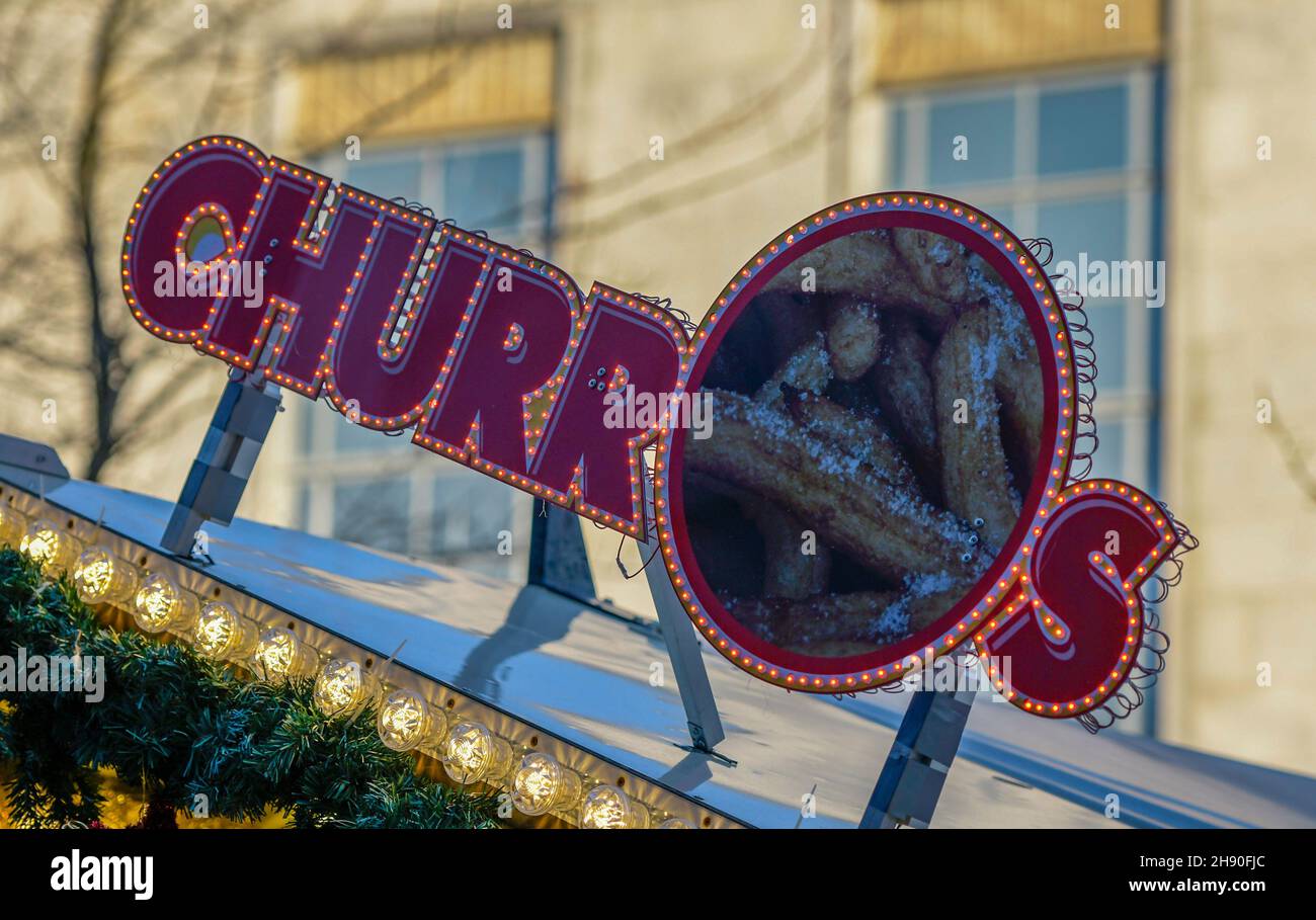 sign advertising churros, sticky sweet donuts, advertising sign for confectionery and sticky sugary trets at a christmas market in southampton centre. Stock Photo