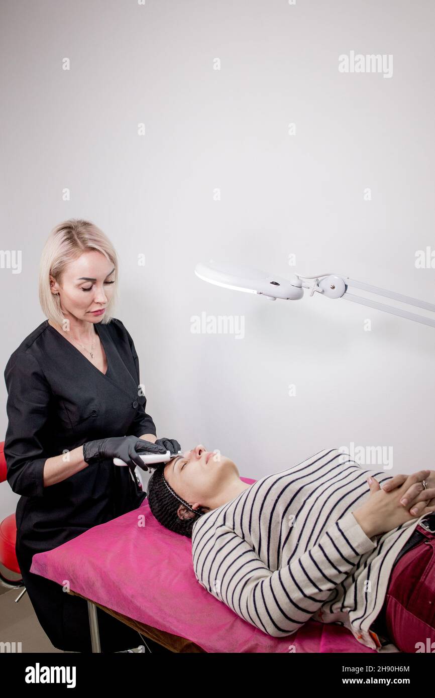 Cosmetologist,beautician making facial treatment with ultrasonic
