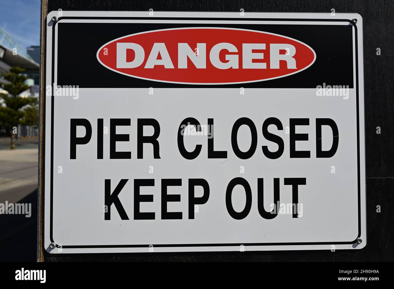 A danger sign warning people to keep out of the closed pier Stock Photo