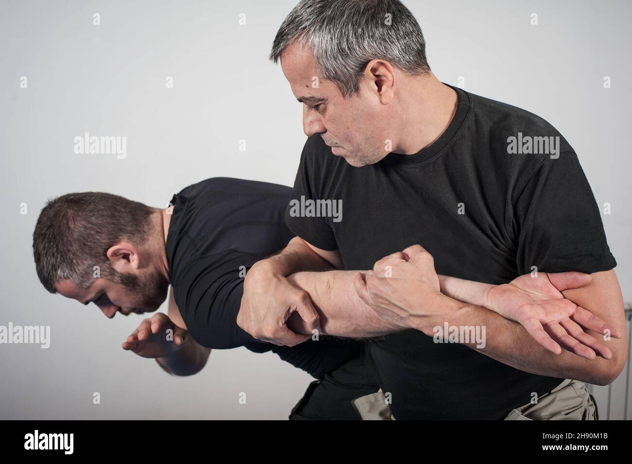 Kapap instructor demonstrates arm bar techniques with his student Stock