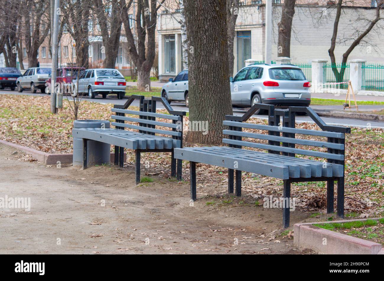 Street benches in the park. Urban environment. Grey wooden bench. Stock Photo