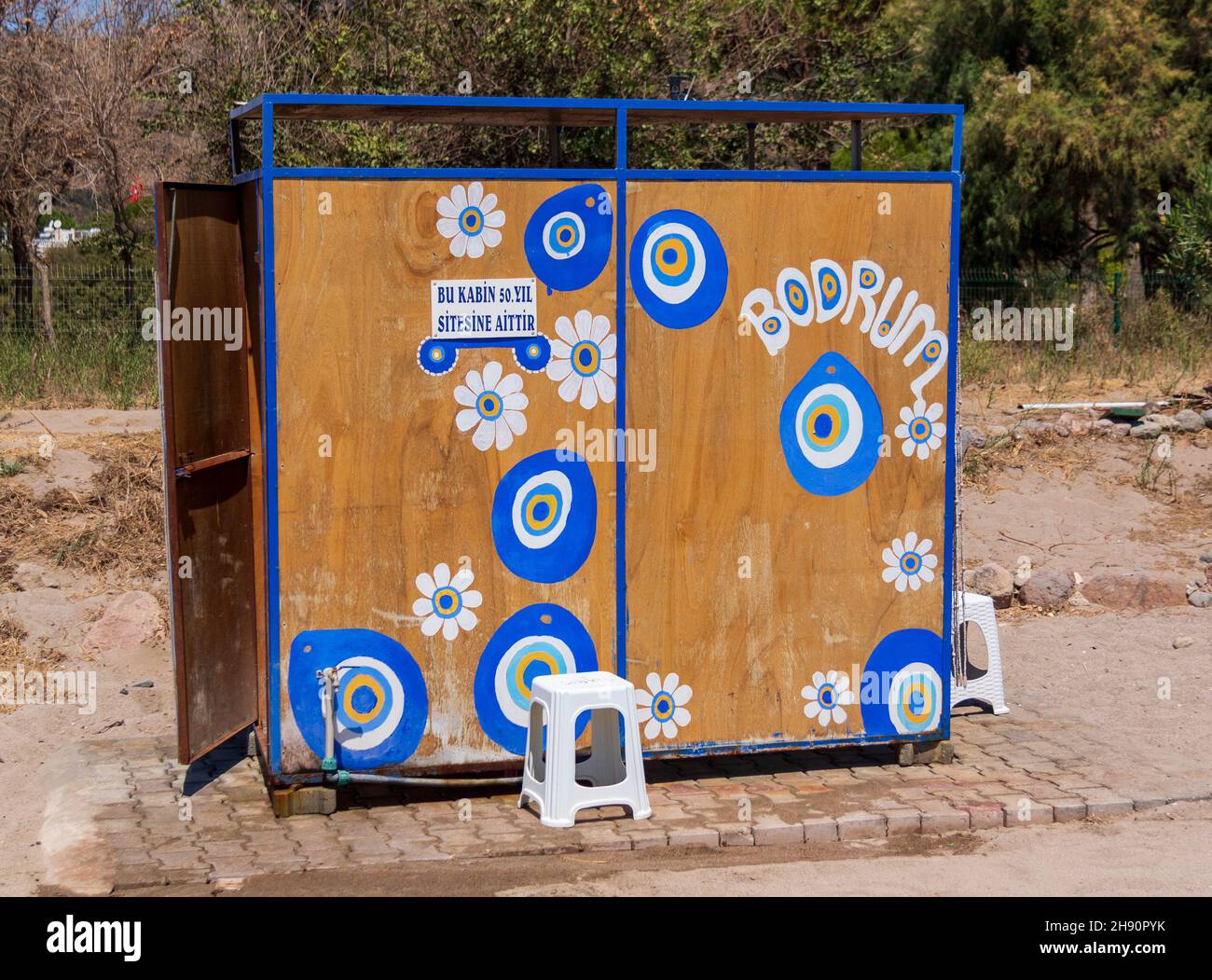 wooden changing cubicle with painted nazar symbol at Camel Beach near Bodrum, Turkey Stock Photo