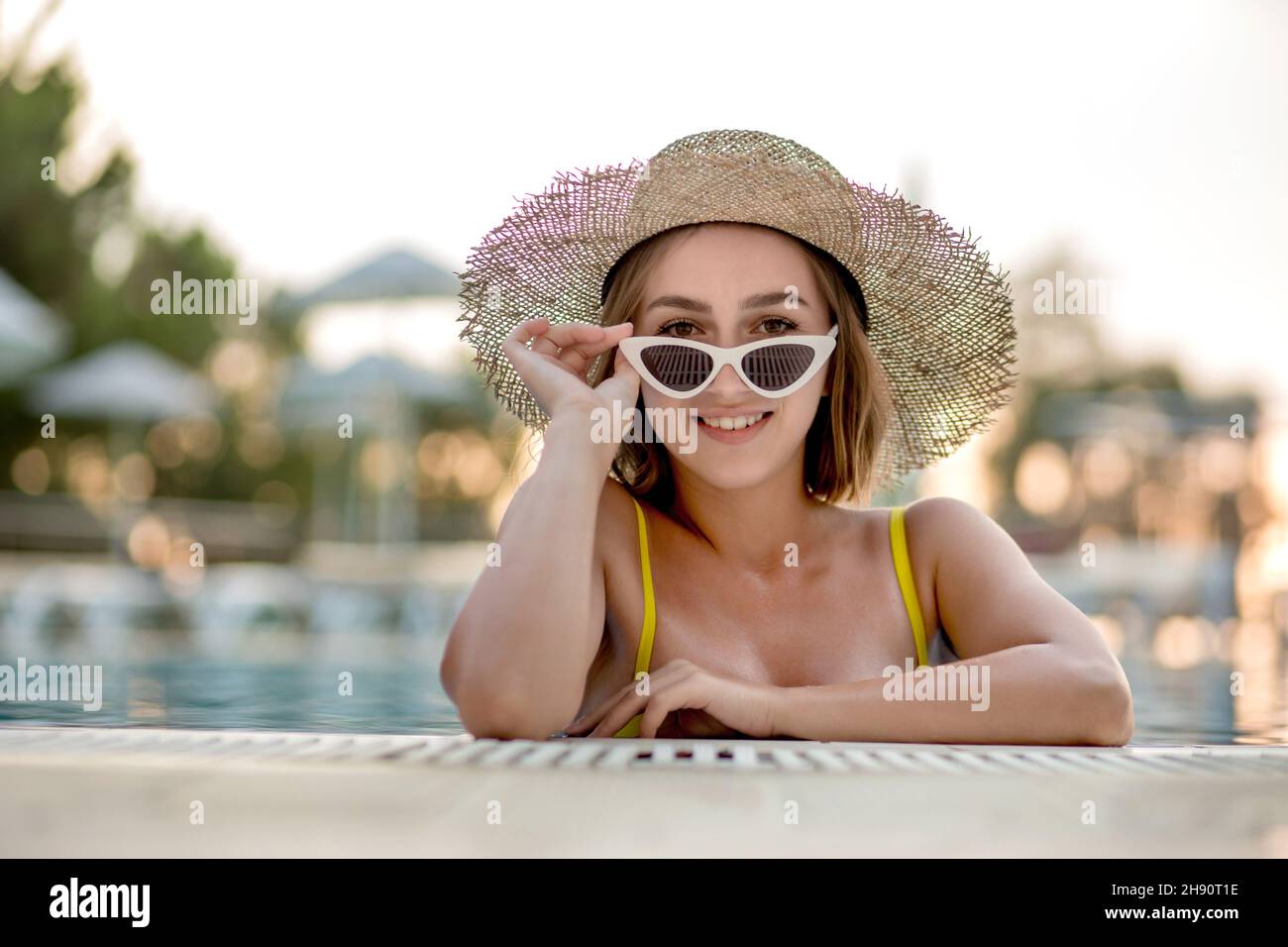 Beautiful woman in a hat and sunglasses relaxing in the pool Stock ...