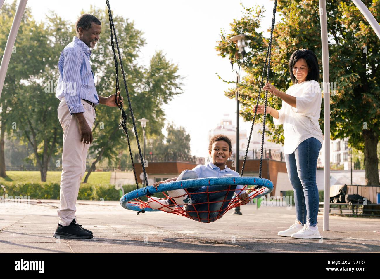 Beautiful happy african american family bonding at the park - Black family having fun outdoors. Stock Photo