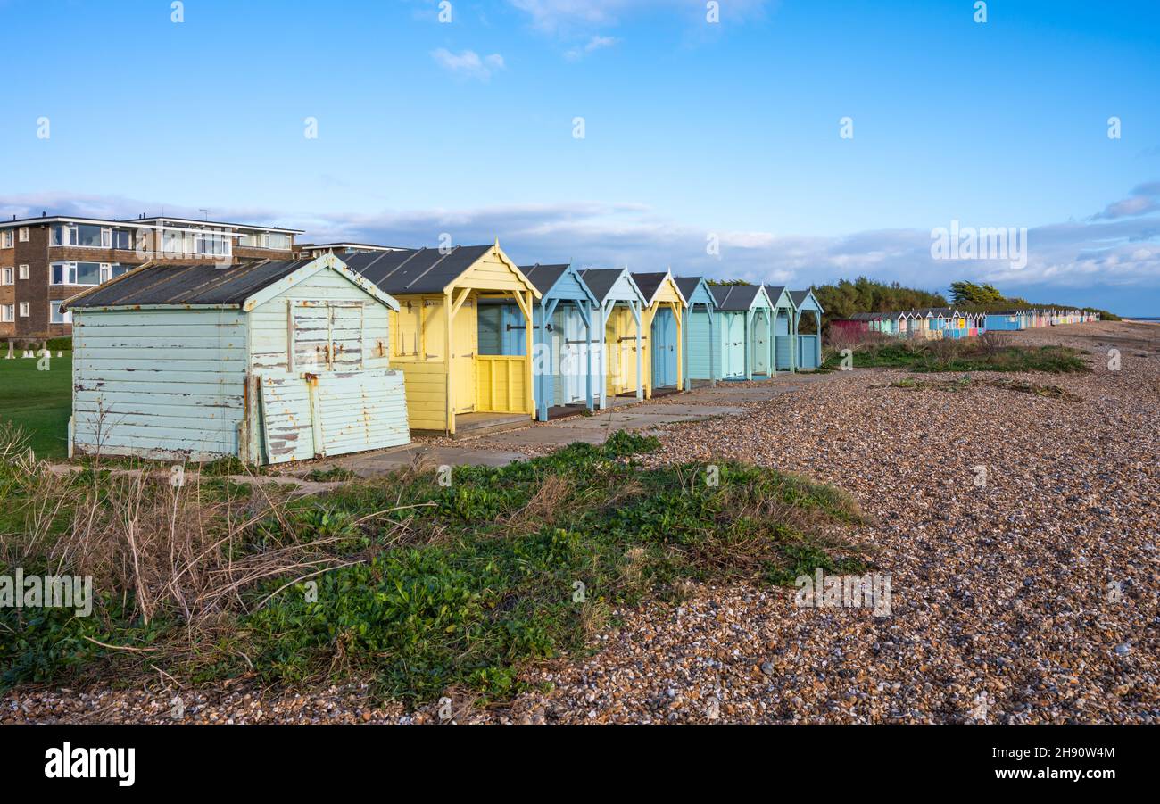 Colourful wooden beach huts on the seafront on the shingle beach along the South Coast coastline in Rustington, West Sussex, England, UK. Stock Photo