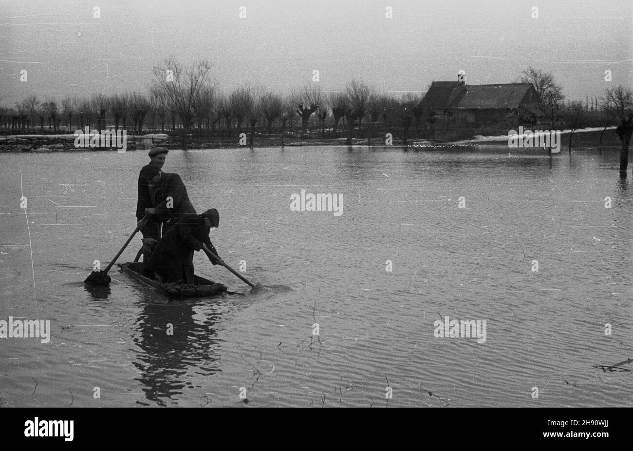 Wyszogród, 1947-03. Wiosenna powódŸ roztopowa na Wiœle, spotêgowana zatorami lodowymi. Nz. powodzianie w prowizorycznej ³ódce z drewnianego koryta. kw  PAP  Dok³adny dzieñ wydarzenia nieustalony.      Wyszogrod, March 1947. Spring flood on the Vistula River, intensified by ice jams. Pictured: flood victims in wooden trough serving as a makeshift boat.  kw  PAP Stock Photo