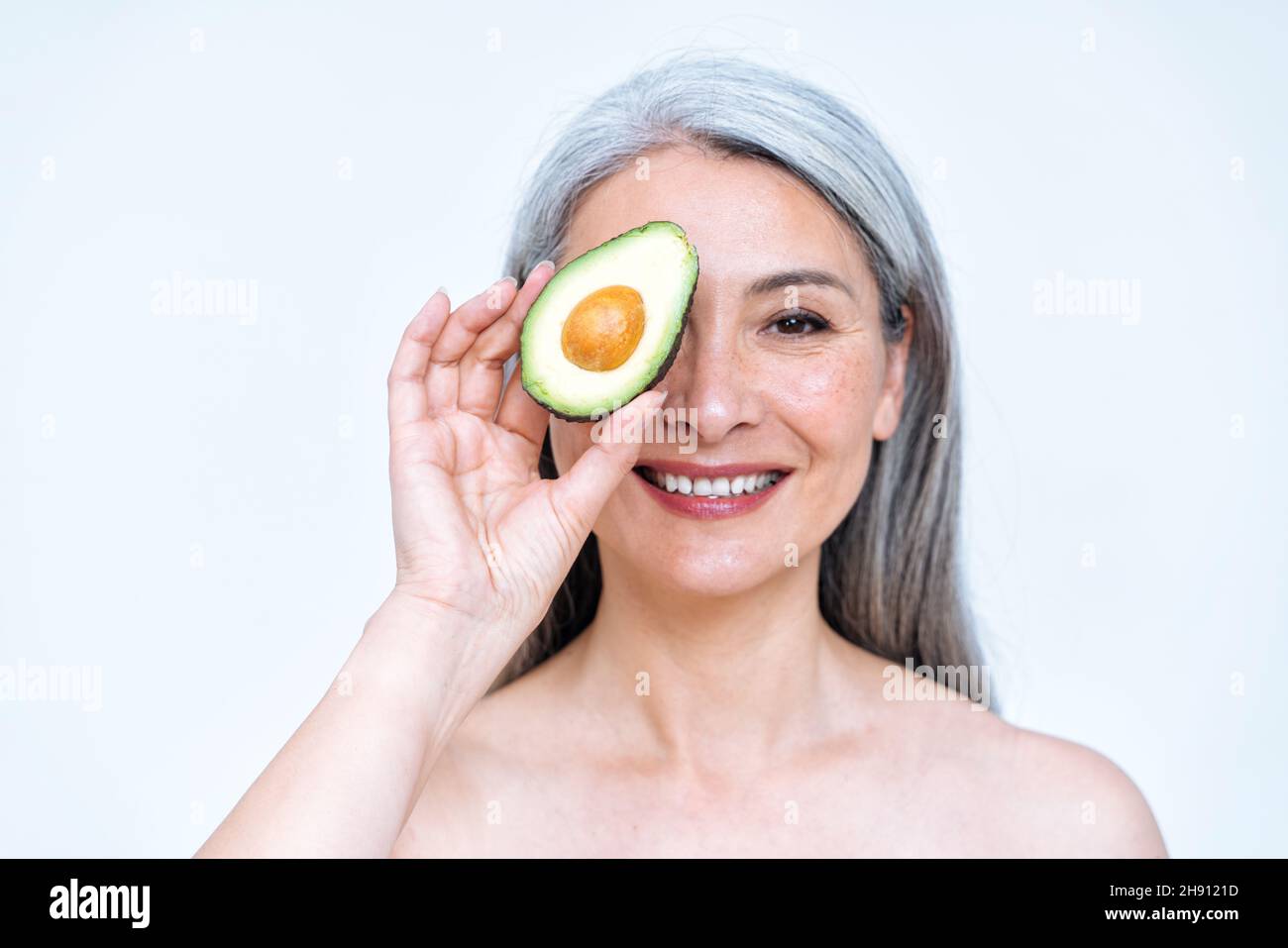 Image of a senior woman posing in studio for a body positive concepts photoshooting. old model showing fruits and healthy food good for the skin care Stock Photo