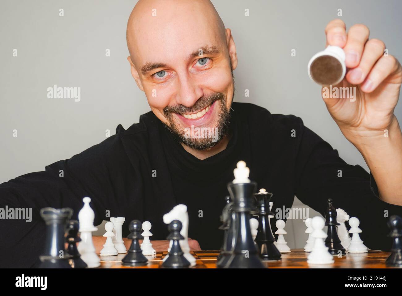 Pensive african american man thinking about next chess move while sitting  at table. Stock Photo by DC_Studio