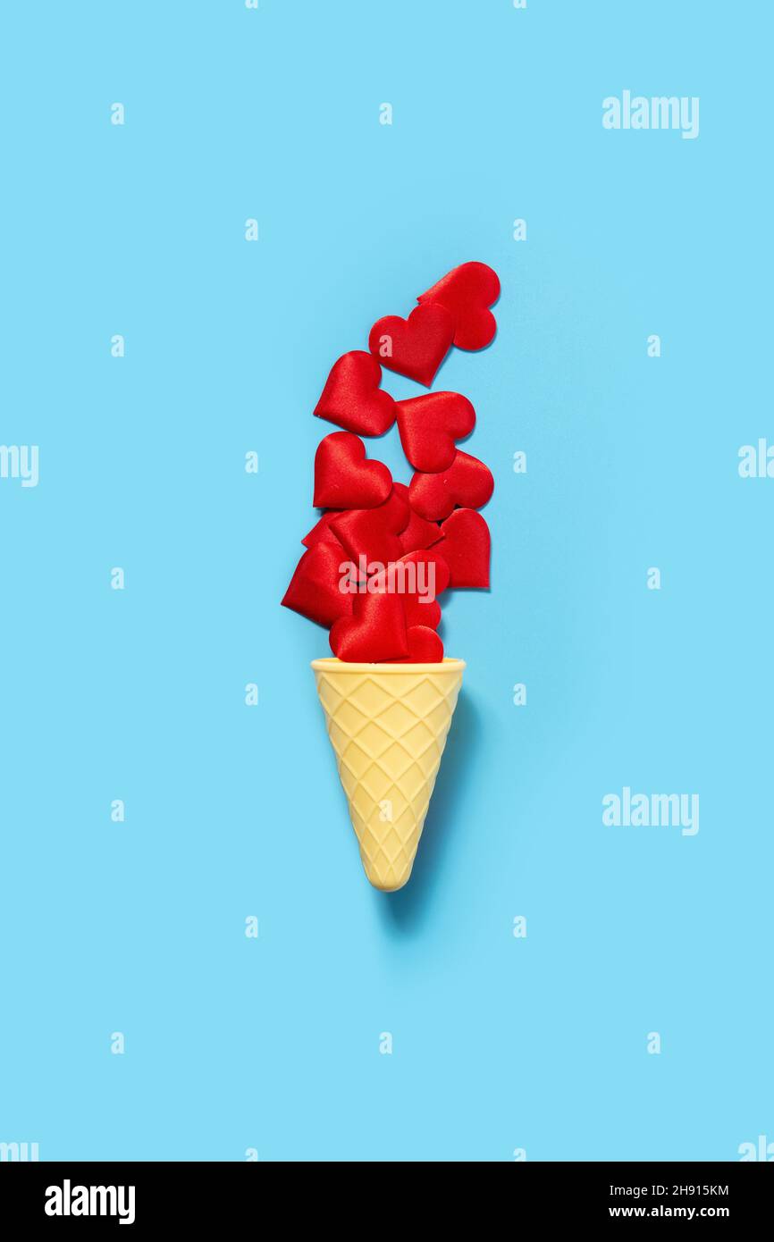 Ice cream cone with red hearts on blue background Stock Photo