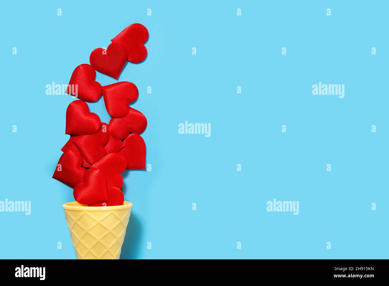Ice cream cone with red hearts on blue background Stock Photo