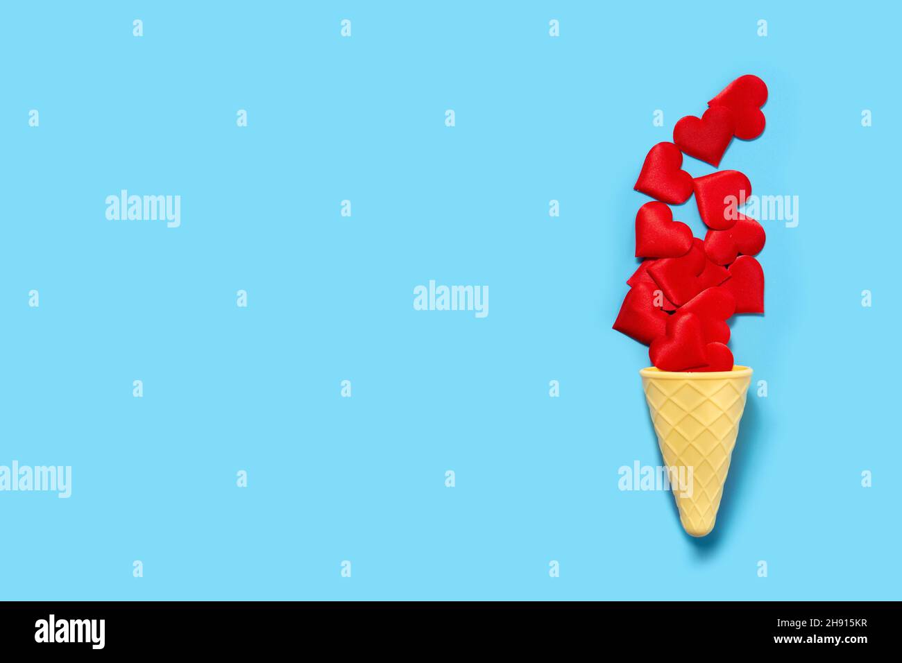 Ice cream cone with red hearts on blue background Stock Photo