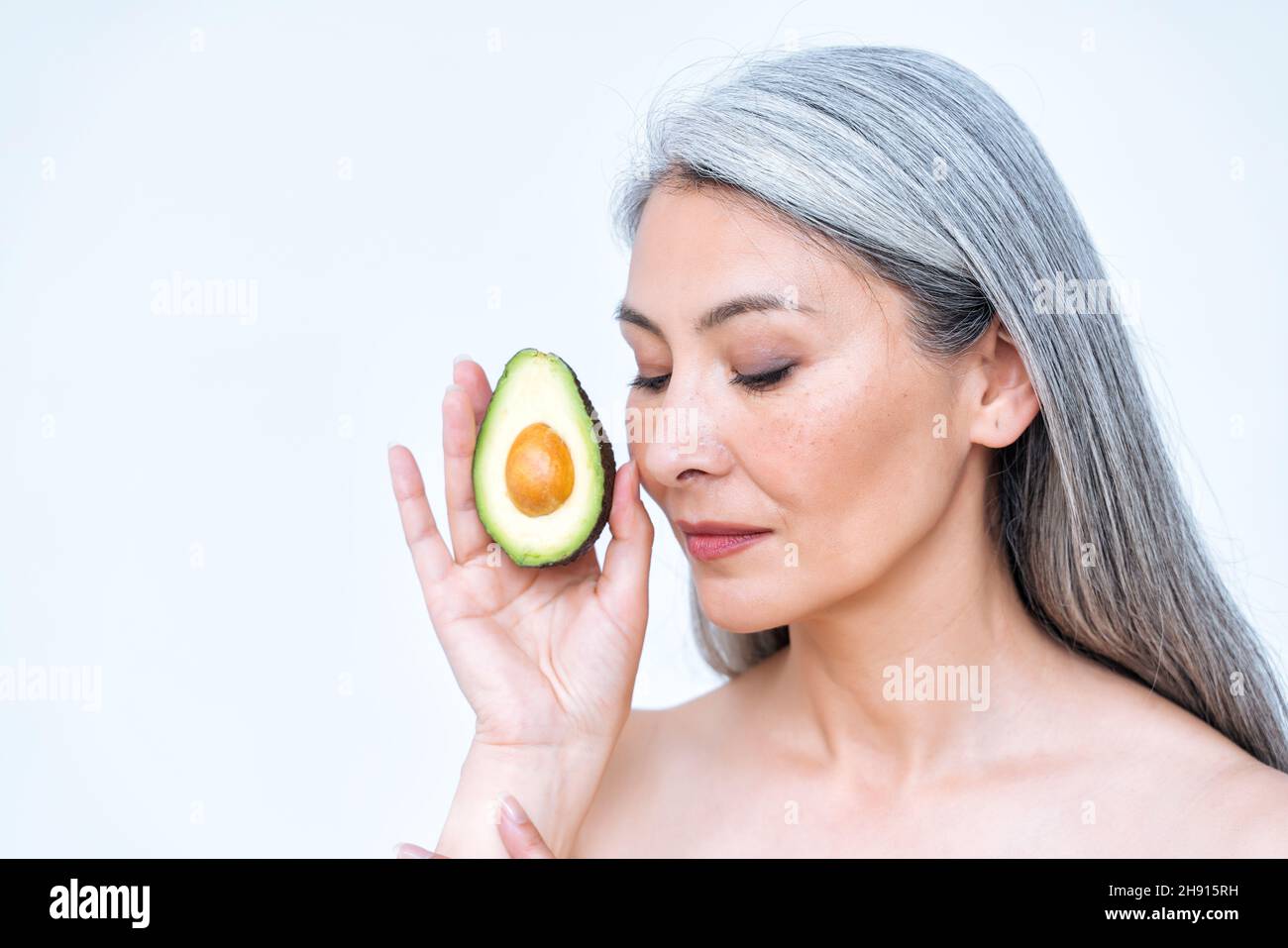 Image of a senior woman posing in studio for a body positive concepts photoshooting. old model showing fruits and healthy food good for the skin care Stock Photo