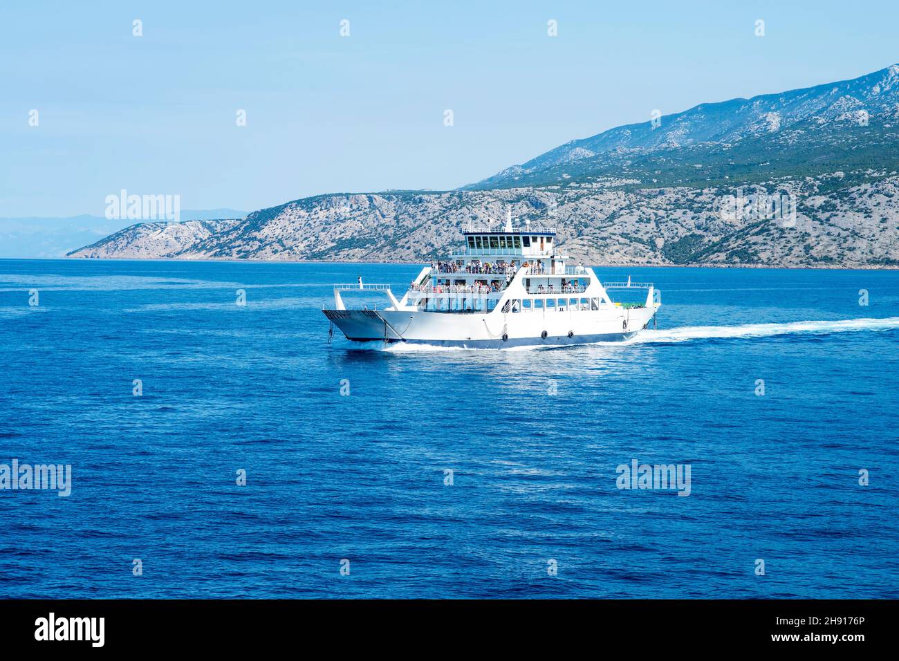 Car ferry boat in Croatia linking the island Rab to mainland passing by on adriatic sea. Stock Photo