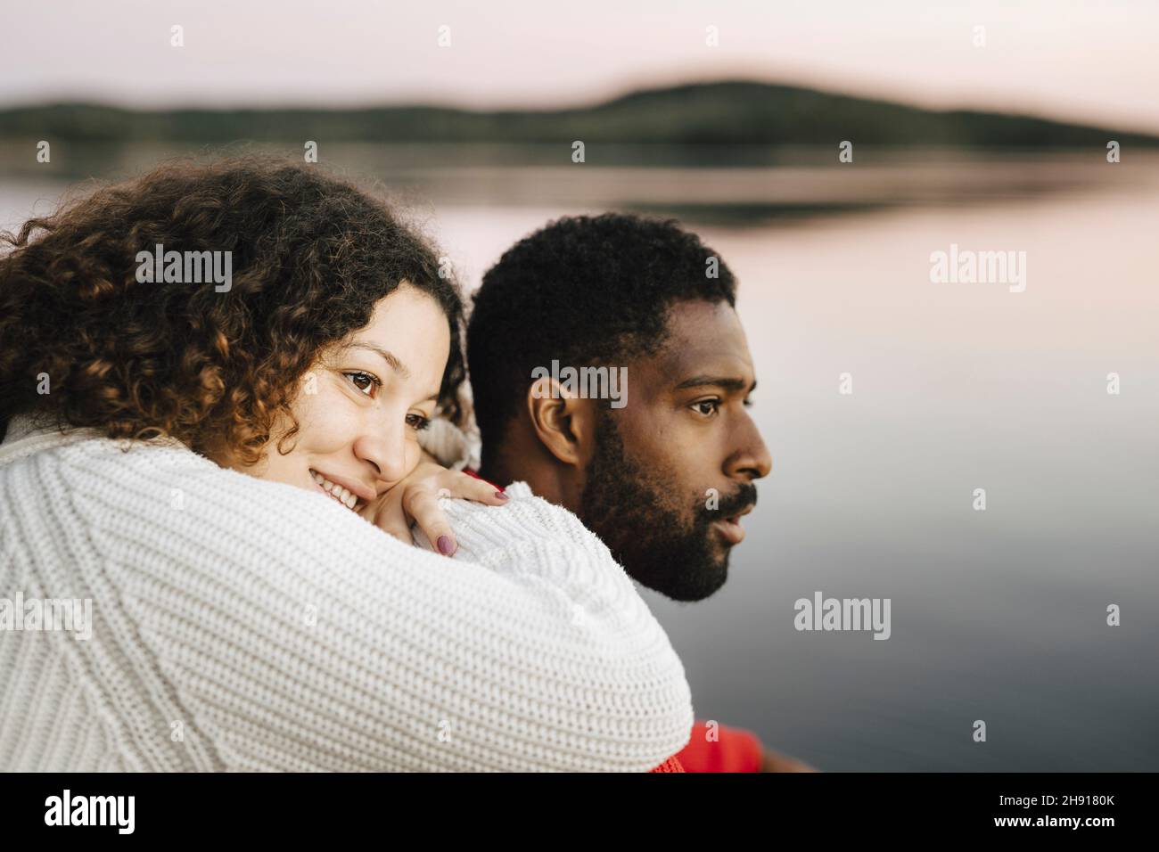 Contemplative couple looking away during sunset Stock Photo