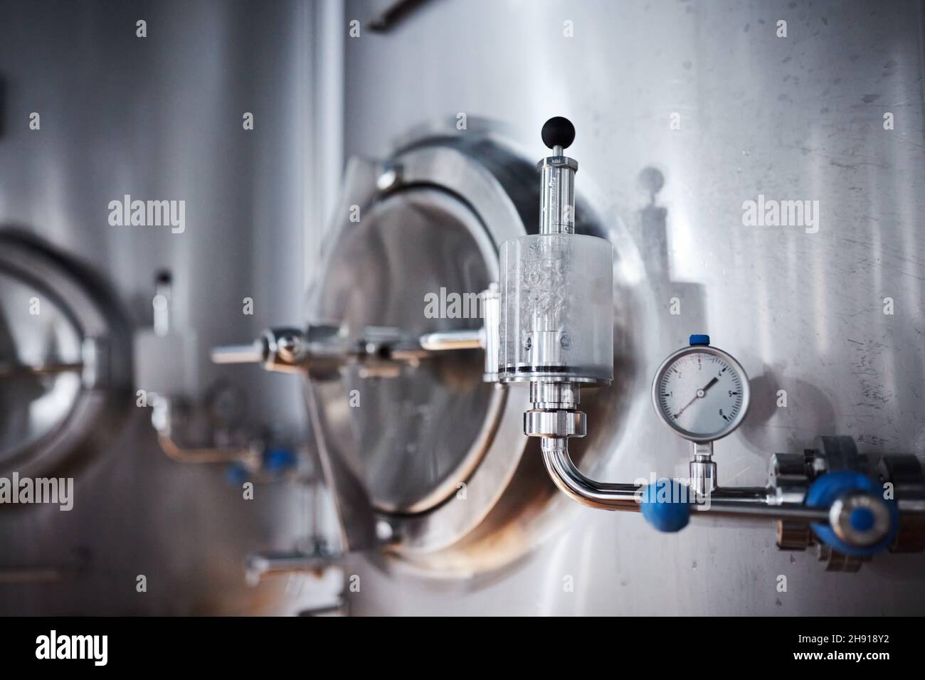 Equipment for the production of craft beer, containers for fermentation in the climatic chamber, pressure gauge with tubes and stainless steel tanks. Stock Photo