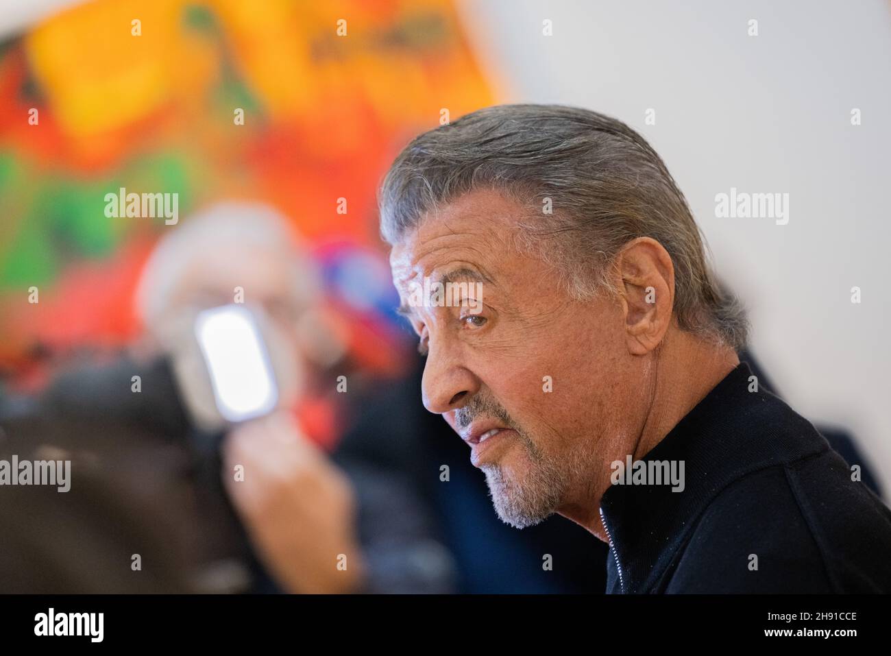 Hagen, Germany. 03rd Dec, 2021. Sylvester Stallone, actor, walks through his exhibition 'Sylvester Stallone - 75th Birthday Retrospective' at the Osthaus Museum. He is world famous as Rocky or Rambo. But Hollywood star Sylvester Stallone also has an artistic side. His work as a painter is now being shown in Germany for the first time - for the opening of the show he is coming personally to the Ruhr area in Hagen. Credit: Rolf Vennenbernd/dpa/Alamy Live News Stock Photo