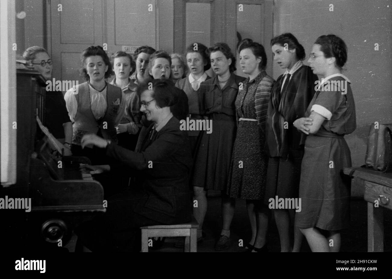 Piaseczno, 1947-04. Liceum ¯eñskie Gospodarstwa Wiejskiego w Chyliczkach. Nz. chór szkolny. Przy pianinie sekretarka szko³y Kazimiera Sobañska. Od lewej stoj¹: W. Je³owicka, L. Królówna, R. Grabiñska, W. Wendówna, I. Marciñczak, W. Szymañska, E. Krotki, J. Tchórzewska, J. £aczyñska, L. S³upczyñska, L. Bogus³awska. wb PAP Dok³adny dzieñ wydarzenia nieustalony. Piaseczno, April 1947: Secondary farming school for girls in Chyliczki. Pictured: a school choir. At the piano school secretary Kazimiera Sobanska. From left standing: W. Jelowicka, L. Krolowna, R. Grabinska, W. Wendowna, I. Marcin Stock Photo