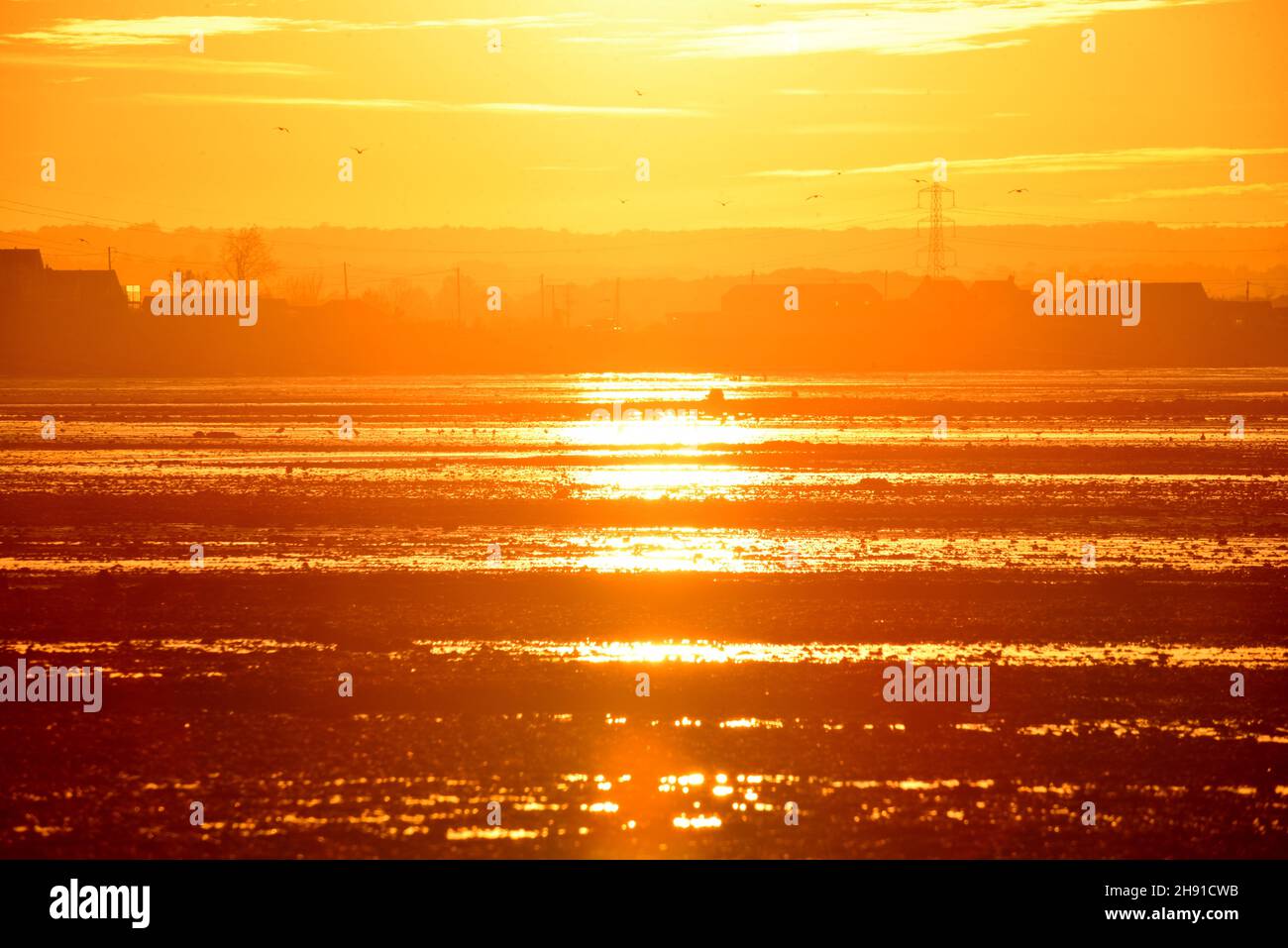 The sun sets in the west at the end of a beautiful November day in Whitstable, Kent Stock Photo