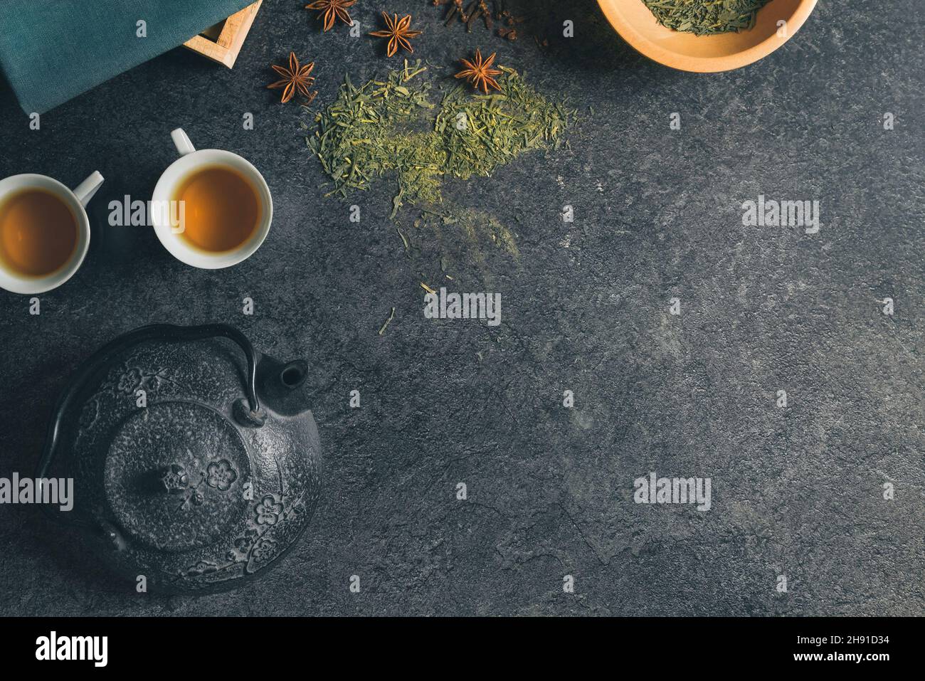 Top studio shot of a still life with vintage black metal Japanese tea pot on a dark stone table. Free copy space for caption. Tea ceremony concept Stock Photo