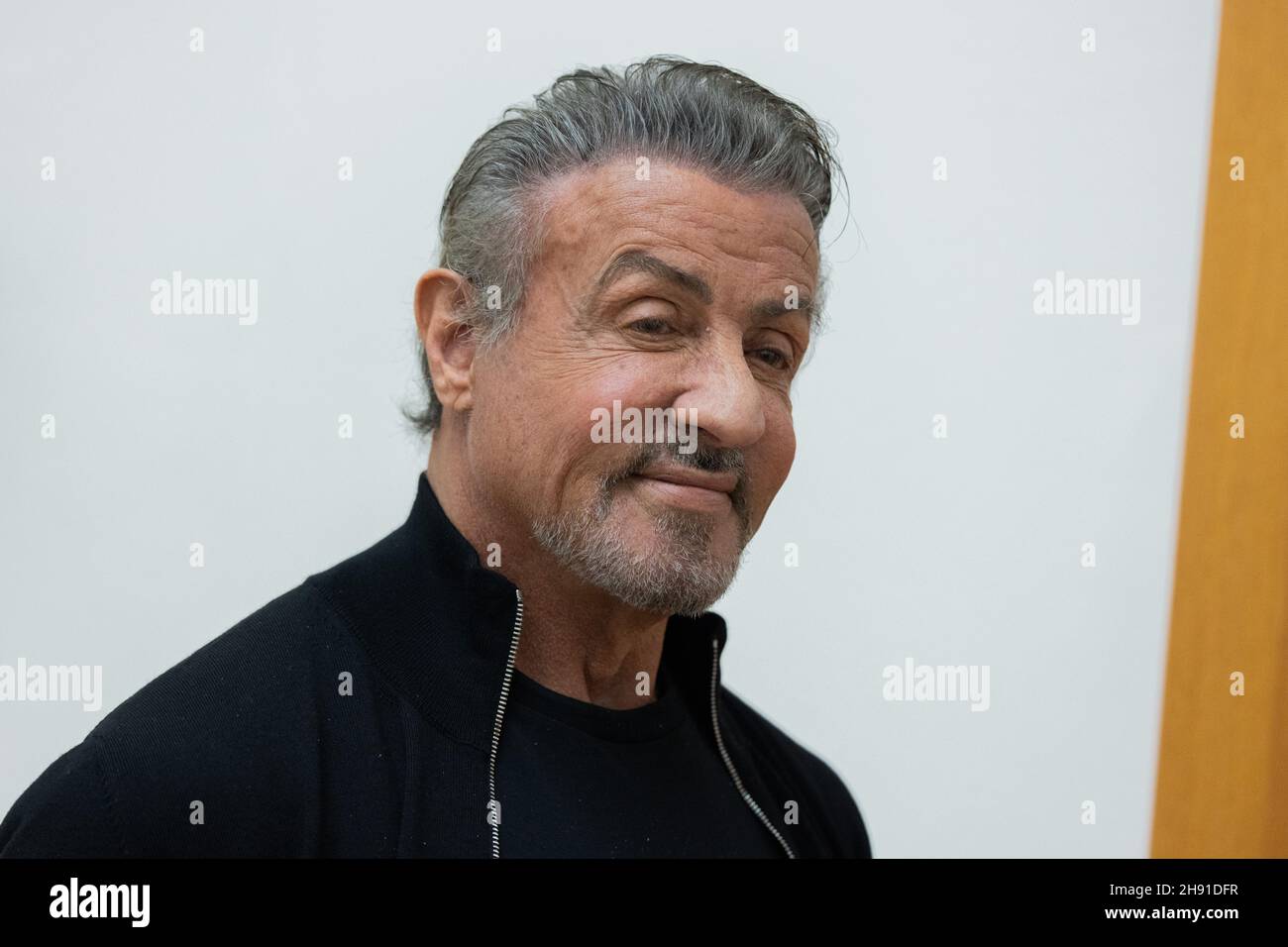 Hagen, Germany. 03rd Dec, 2021. Sylvester Stallone, actor, walks through his exhibition 'Sylvester Stallone - 75th Birthday Retrospective' at the Osthaus Museum and smiles. He is world famous as Rocky or Rambo. But Hollywood star Sylvester Stallone also has an artistic side. His work as a painter is now being shown in Germany for the first time - for the opening of the show he is coming personally to the Ruhr area in Hagen. Credit: Rolf Vennenbernd/dpa/Alamy Live News Stock Photo