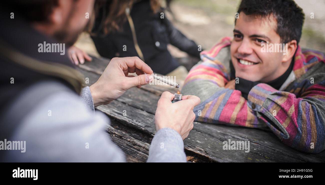 Man heats and lights marihuana or hashish joint cigarette to burn