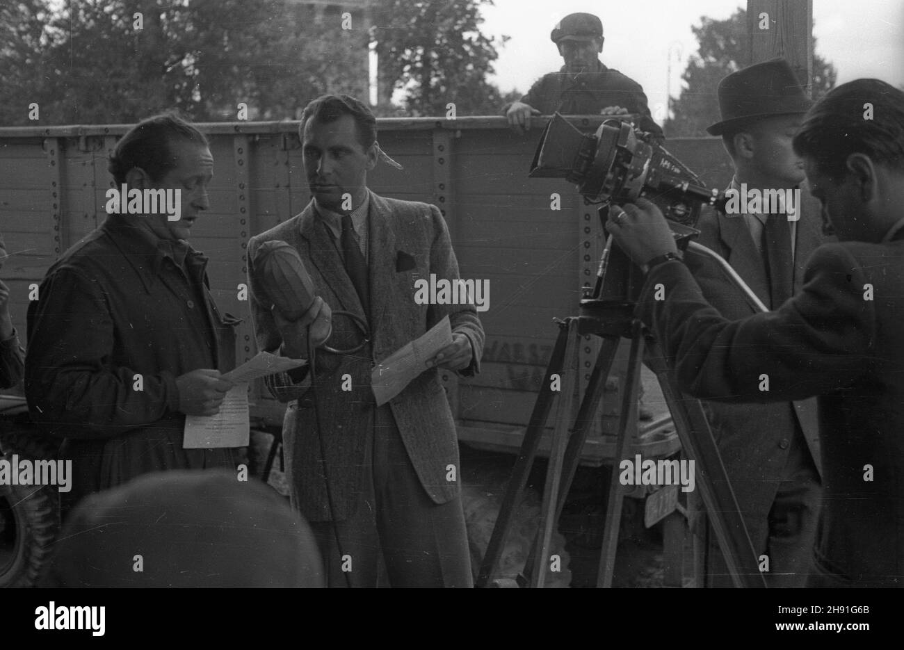 Warszawa, 1947-05. Pracownik Polskiego Radia Tadeusz Pyszkowski (z mikrofonem) przy nagrywaniu w Ogrodzie Saskim audycji z udzia³em operatora Przedsiêbiorstwa Pañstwowego Film Polski W³adys³awa Forberta (L). bb/gr PAP Dok³adny dzieñ wydarzenia nieustalony. Warsaw, May 1947. A Polish Radio employee Tadeusz Pyszkowski (with a mike) recording a programme with the participation of Film Polski cameraman Wladyslaw Forbert (from left) in the Saski Garden. bb/gr PAP Stock Photo