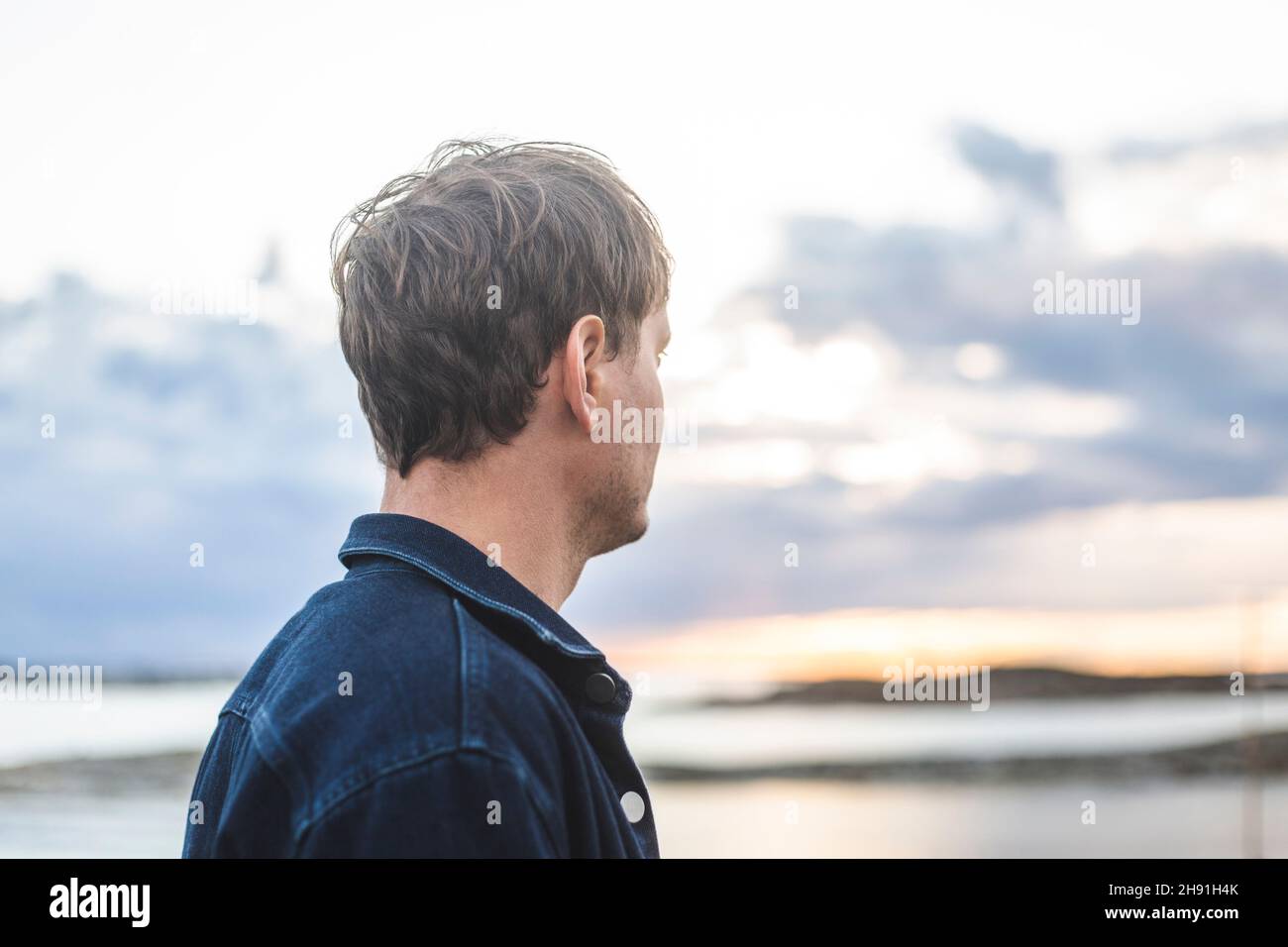 Side view of mid adult man looking at view during sunset Stock Photo
