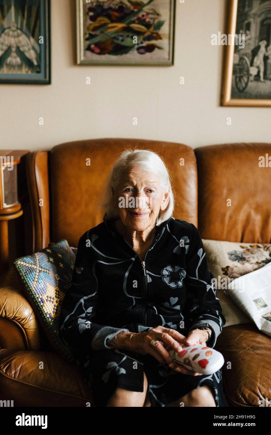 Senior woman sitting on sofa hi-res stock photography and images - Alamy