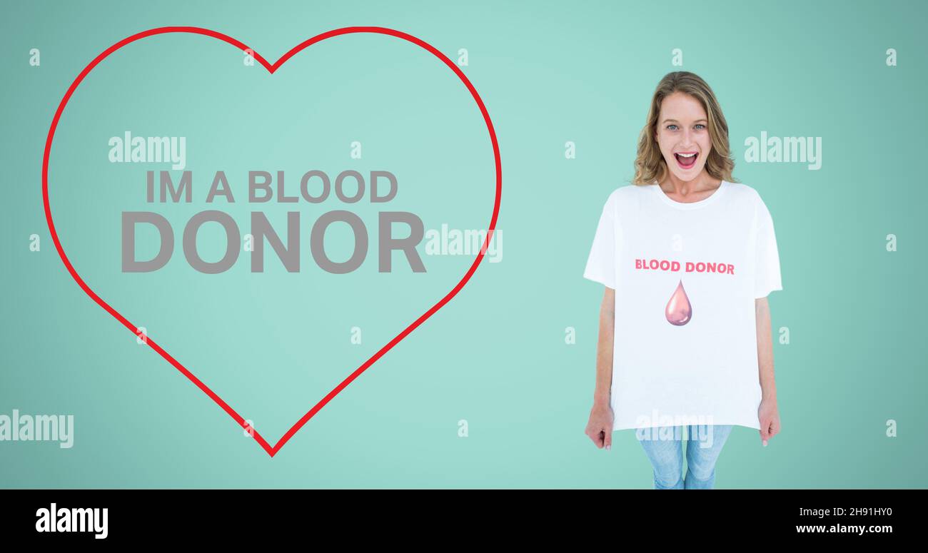 Im a blood donor text in red heart shape by smiling woman showing tshirt on blue background Stock Photo