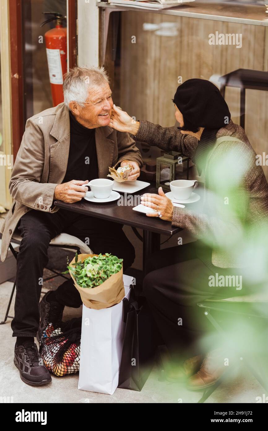 Elderly couple talking while having breakfast at sidewalk cafe Stock Photo