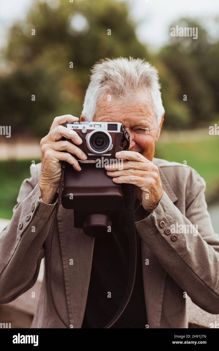 Senior man photographing with camera during weekend Stock Photo