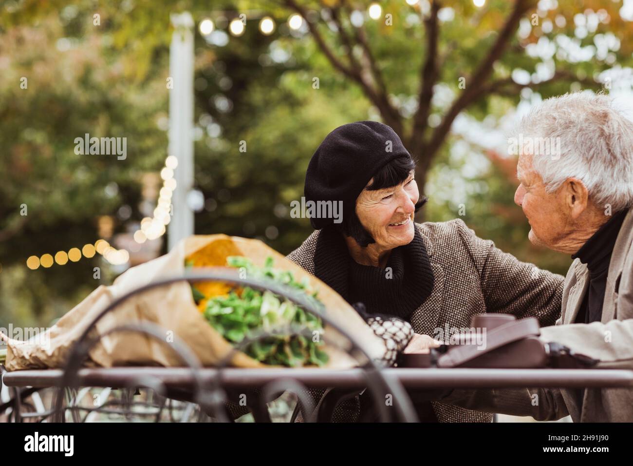 Smiling senior woman looking at man in park during vacation Stock Photo