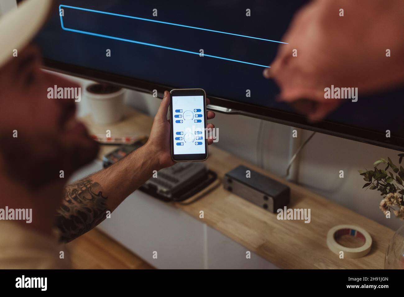 Male maintenance engineer showing app on smart phone to customer at home Stock Photo