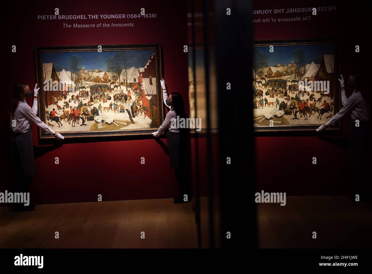 Gallery assistants with the Massacre of the Innocents, Pieter Brueghel the Younger (1564 - 1638), estimated between £1,000,000 - £1,500,000, during a photo call for highlights from the forthcoming Classic Week Sales, at Christies, London. The sale includes works by El Greco and Constable, and the Darwin family microscope. Picture date: Friday December 3, 2021. Stock Photo