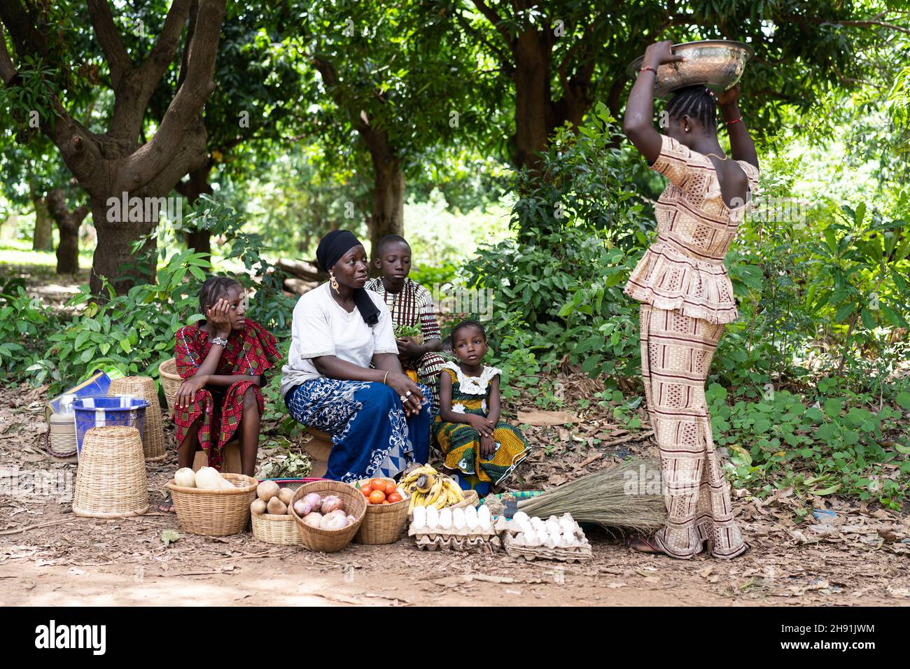 Typical African street market scene with black women and children trading home-grown vegetables and goods Stock Photo