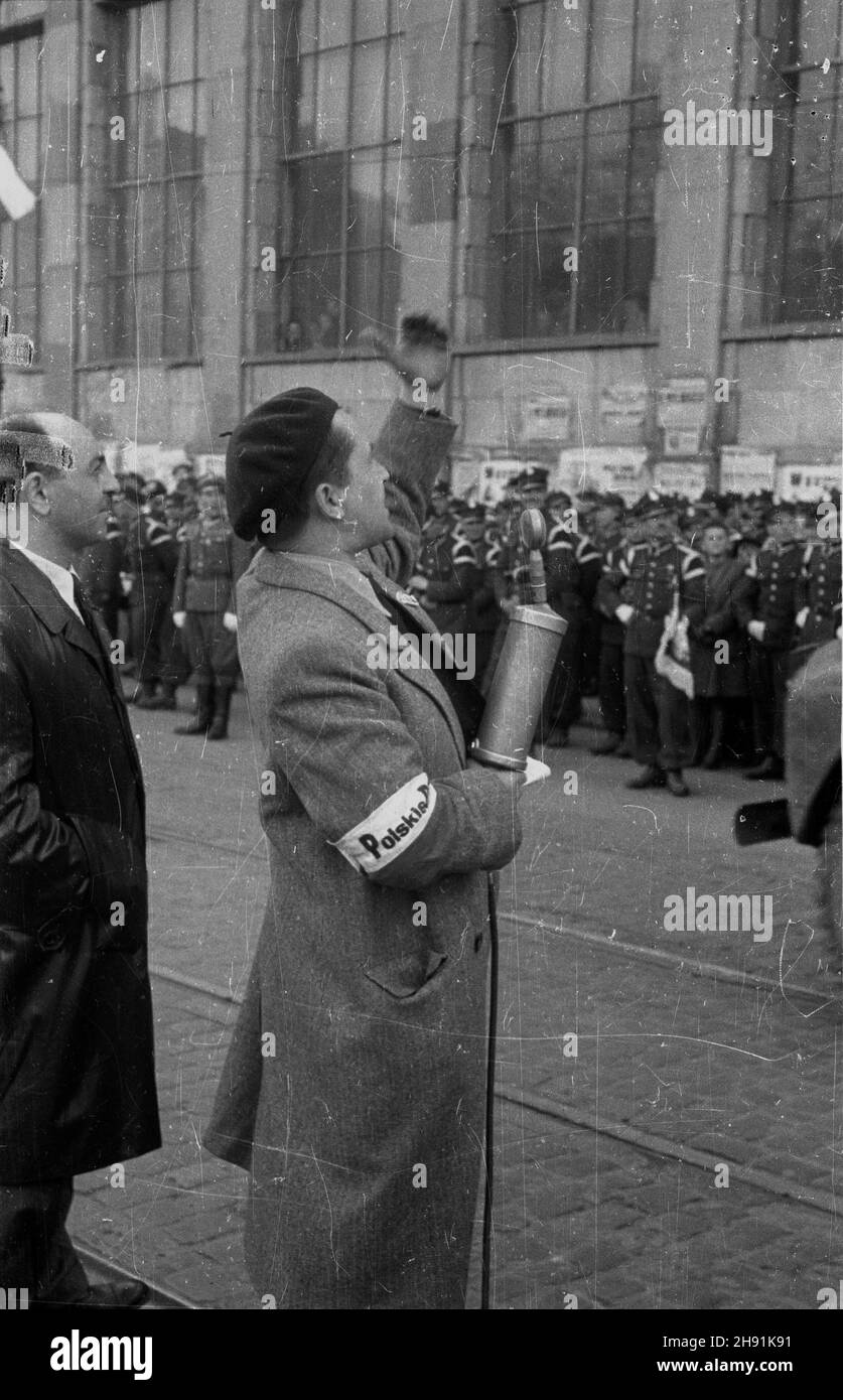 Warszawa, 1947-05-01. Pochód pierwszomajowy w Alejach Jerozolimskich. Nz. sprawozdawca Polskiego Radia z mikrofonem. W tle gmach Banku Gospodarstwa Krajowego. bb/ms  PAP      Warsaw, May 1, 1947. A Mayday parade in Jerozolimskie Avenues. Pictured: a Polish Radio reporter with microphone in front of the National Economy Bank.   bb/ms  PAP Stock Photo