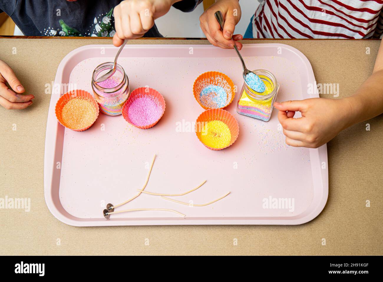 Young children making fun colorful layered granulated wax candles in
