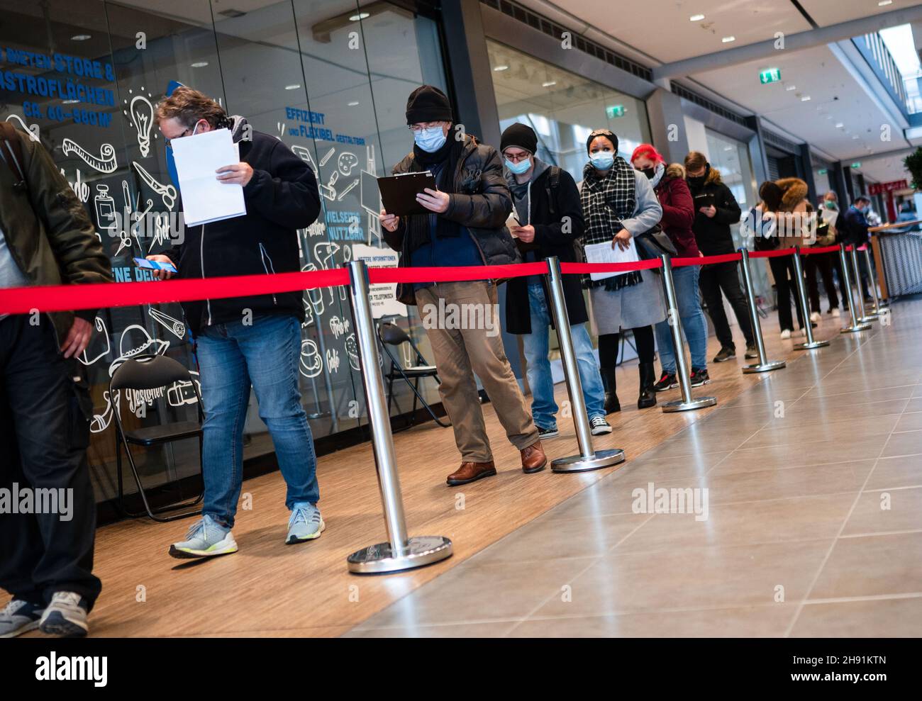 Aachen, Germany. 03rd Dec, 2021. People queue in front of the vaccination centre in the Aachen-Arkaden shopping centre. A 60-hour vaccination marathon has begun here. In order to cope with the high demand for Corona vaccinations, the Städteregion is offering vaccinations in the Aachen-Arkaden shopping centre around the clock for three days this weekend. Credit: Marius Becker/dpa/Alamy Live News Stock Photo