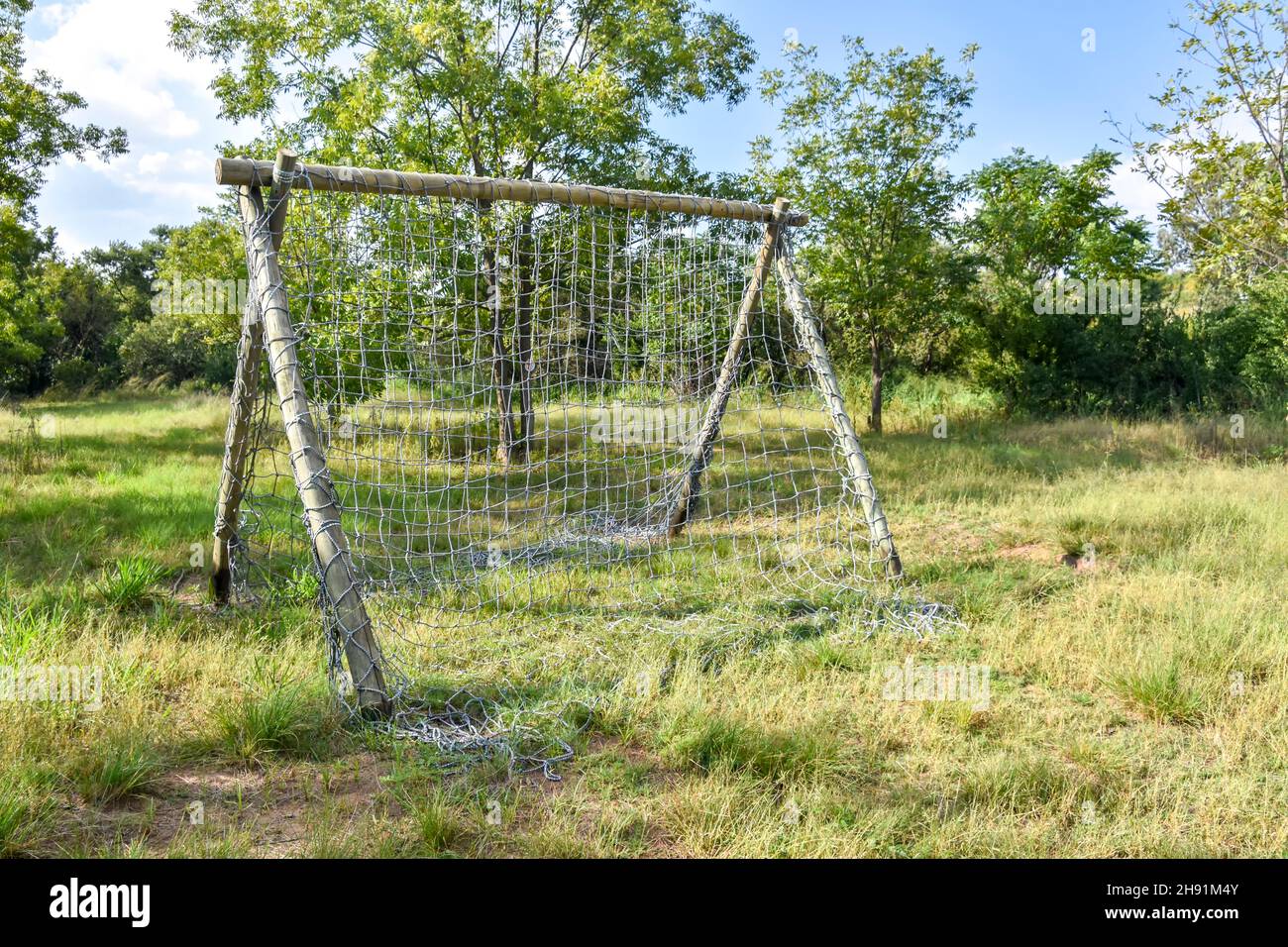 A climbing rack made of wooden poles and a net made for an obstacle course in a grass field to test the endurance and agility of sports people and oth Stock Photo