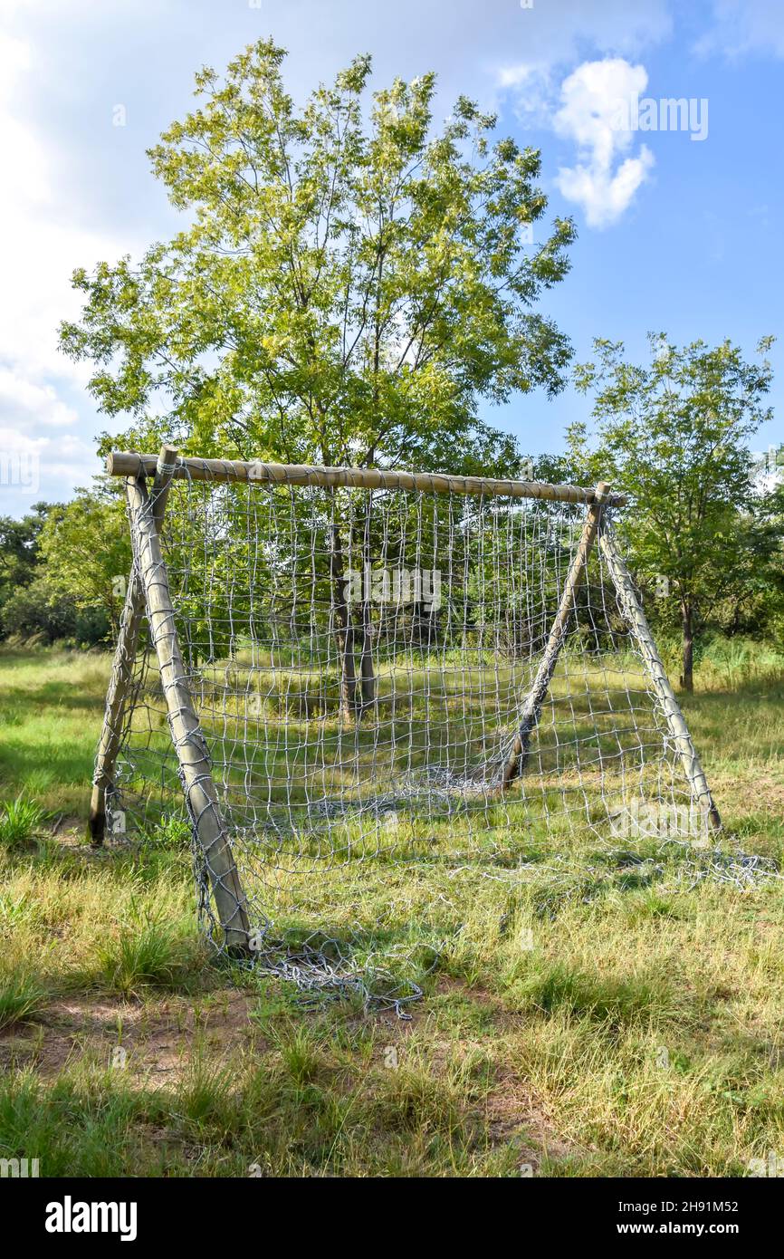 A climbing rack made of wooden poles and a net made for an obstacle course in a grass field to test the endurance and agility of sports people and oth Stock Photo